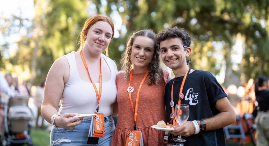group of three young alumni standing together